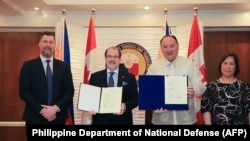 菲律宾国防部长吉尔伯特·特奥多罗(右二)与加拿大驻菲律宾大使戴维·哈特曼(David Bruce Hartman 左二)在马尼拉签署了防务合作谅解备忘录。(2024年1月19日)