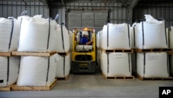 Para pekerja memuat karung-karung litium karbonat di gudang Albermarle Corp. 6 Oktober 2022, di Silver Peak, Nevada. (Foto: John Locher/AP Photo)