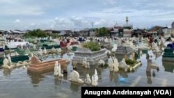 Tempat pemakaman umum di Medan Belawan, Sumatra Utara, terendam banjir rob imbas dari perubahan iklim, Jumat, 19 Mei 2023. (VOA/Anugrah Andriansyah)