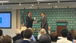 美国智库哈德逊研究所中国中心主任余茂春(Miles Yu)向海曼资本的创始人巴斯(Kyle Bass)7月13日向赠予印有小熊维尼的杯子。巴斯当日发表了关于中国国家主席习近平发动战争时间表的演讲。(美国之音记者薛小山拍摄)