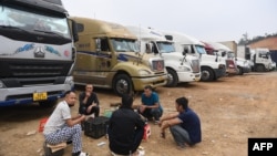 资料照片:2022年1月7日,卡车司机聚集在谅山省的一个临时停车场里休息。越南的集装箱卡车正在那里等待越过中越边境。(法新社照片)