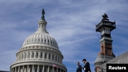 两名男子走过美国国会大厦。(2023年11月15日)