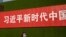 一名女子从北京街头张贴的一条宣传习近平新时代的标语下走过。（2019年9月27日）