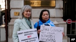 资料照片：人权活动人士海伦娜·肯尼迪（Helena Kennedy）（左）和拉希玛·马赫穆特 （Rahima Mahmut） 举着标语牌在伦敦英国外交部外面抗议,要求英国外相会晤维吾尔活动人士和幸存则。(2023年2月13日，)