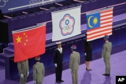 来自台湾的李洋和王齐麟赢得2024巴黎奥运会羽毛球男双金牌后,会场升起台湾在国际赛事上使用的“中华台北”的旗帜。(2024年8月4日)