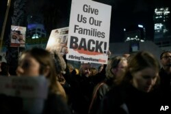 Seorang pria memegang tanda yang menyerukan pembebasan sandera yang dibawa oleh militan Hamas ke Jalur Gaza selama demonstrasi di Hostages Square di Tel Aviv, Israel, 13 Januari 2024. (Foto: AP)