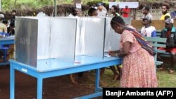 Seorang perempuan suku Papua mengisi surat suaranya di TPS Jayapura di Provinsi Papua bagian timur pada8 Juli 2009. (Foto: AFP /Banjir Ambarita)