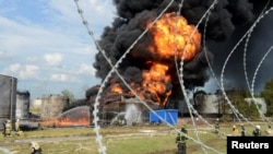 Nhân viên cứu hỏa cố gắng dập lửa tại một thùng nhiên liệu đang bốc cháy của một kho chứa dầu ở Voronezh, Nga, ngày 24 tháng 6 năm 2023.