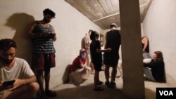 10月16日特拉维夫市中心, 警报声响起后，住在公寓楼的人们躲进楼底掩体里躲避火箭弹 (美国之音/唐丹鸿)