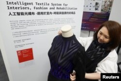 Profesor Jeanne Tan dari Sekolah Mode dan Tekstil di Universitas Politeknik Hong Kong berpose untuk foto dengan 'BOLT SWEATER' yang dibuat dari sistem Tekstil Cerdas yang dikembangkan oleh AiDLab di Hong Kong, China, 5 Juni , 2023. (REUTERS/Joyce Zhou)