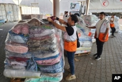 联合国和红新月会的工作人员准备向加沙地带的巴勒斯坦人发放救援物资。(2023年10月23日)