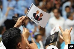 Pendukung calon presiden Ganjar Pranowo dan pasangannya Mahfud Mahmodin bersorak saat pengundian nomor elektoral yang akan mewakili pasangan tersebut pada Pilpres 2024, di KPU Jakarta, 14 November 2023. (Foto: AP)