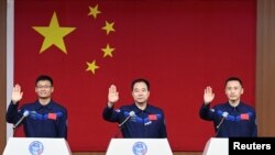 三名中国宇航员在酒泉卫星发射中心出席记者会。(2023年5月29日)