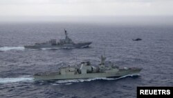 资料照片:美国海军导弹驱逐舰“钟云号”与加拿大皇家海军护卫舰“蒙特利尔号”在南中国海进行演习期间并肩航行。(2023年5月30日)