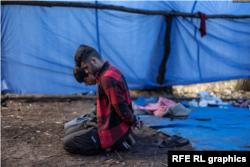 9月12日塞尔维亚苏博蒂察市附近的匈牙利边境附近的临时营地里,被拘留的移民双手戴着手铐跪坐在地上。