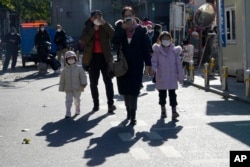 Warga mengenakan masker saat melewati rumah sakit anak-anak di Beijing, Jumat, 24 November 2023. (AP/Ng Han Guan)
