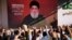 Pendukung kelompok Hizbullah yang didukung Iran mengacungkan tinju dan bersorak ketika pemimpin Hizbullah Sayyed Hassan Nasrallah muncul melalui tautan video selama rapat umum di Beirut, Lebanon hari Jumat, 3 November 2023.