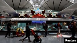 资料照：旅客走在北京大兴国际机场内的五星装饰。（2023年4月24日）