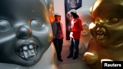 中国艺术家高氏兄弟在他们位于北京的工作室里走过他们的一些“毛小姐”作品。(路透社:2007年10月16日)