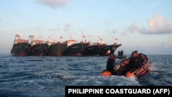 资料照:菲律宾海岸警卫队发布照片显示其巡逻艇驶过停泊在南中国海牛轭礁附近的多艘中国船只。(2021年4月14日)