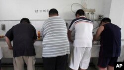 资料照:天津一家减肥医院的肥胖病人在午饭后自己洗碗。(2008年7月24日)