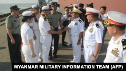 缅甸军事信息小组照片显示,缅甸海军高官(右)欢迎中国海军官兵抵达仰光迪洛瓦港。(2023年11月27日)