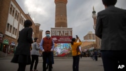 资料图:2021年4月21日游客在政府组织的外国记者旅行中在新疆维吾尔自治区乌鲁木齐拍照。