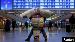 资料照:北京火车站里一名携带个人财产的旅客。(2021年1月13日)