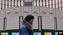一名女子走过位于北京的中国人民银行。(2024年2月20日)