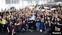 特斯拉首席执行官埃隆·马斯克与上海特色超级工厂的工人们合影。(2023年5月31日)