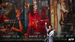 一名女子在电视剧《繁花》剧照前留影。(2024年1月7日)