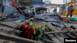 俄占城市顿涅茨克的一个市场遭到炮击后，一束纪念死难者的鲜花摆放在废墟上。（2024年1月22日）