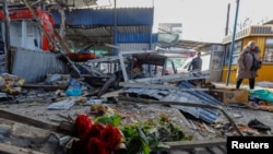 俄占城市顿涅茨克的一个市场遭到炮击后,一束纪念死难者的鲜花摆放在废墟上。(2024年1月22日)