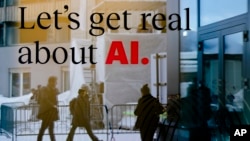 资料照片:2024年1月15日,在瑞士达沃斯举行的世界经济论坛上,映照在一家酒店的窗户上的人群。(美联社照片)