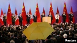 Ông Paul Zimmerman, hội viện hội đồng quận, giơ cao chiếc ô (dù) vàng khi trưởng Đặc khu Hành chính Lương Chấn Anh (thứ 5 bên phải) cùng các quan chức khác nâng rượu mừng tại một buổi tiếp đón sau lễ kéo cờ nhân ngày Quốc khánh Trung Quốc, 1/10/2014.