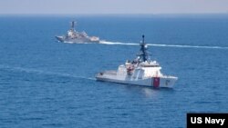 美国海军公布的图片显示美国海军“基德”号阿利·伯克级导弹驱逐舰与美国海岸警卫队“蒙罗”号传奇级巡逻舰在当地时间2021年8月27日例行穿越台湾海峡的国际水域。