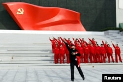 北京的中国共产党历史展览馆内参观者在中共党旗下摆姿势拍照。(2022年10月13日)