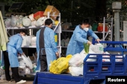 北京一居民区因疫情被封后保安们卸下小区居民购买的食品袋。(2022年10月20日)