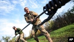 Українські військові очищають дуло гаубиці поблизу Сіверська Донецької області. 1 жовтня 2022 року