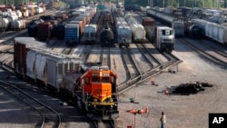 资料照片:BNSF铁路公司的工人在伊利诺伊州盖尔斯堡看着货运列车驶离货运站。(2021年6月15日)