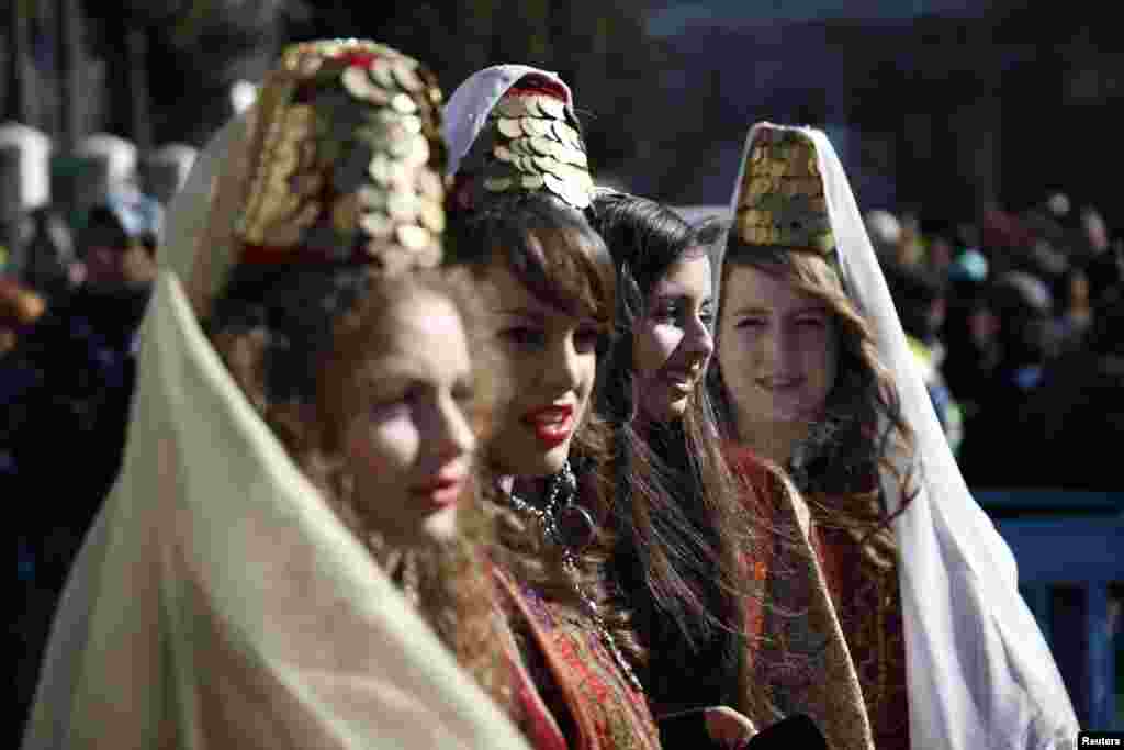 Girls wearing traditional Palestinian costumes take part in a Christmas procession at Manger Square in front of the Church of the Nativity in the West Bank town of Bethlehem, Dec. 24, 2013.