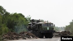 在巴赫穆特附近,一辆乌克兰军车把一辆坦克拖走。(2022年8月15日)