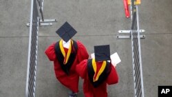 Para mahasiswa berjalan memasuki stadion High Point Solutions sebelum acara wisuda Universitas Rutgers dimulai di Piscataway Township, New Jersey, pada 13 Mei 2018. (Foto: AP/Seth Wenig)