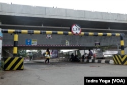 Seorang warga melintasi Jembatan Antelope di Curug, Bekasi, Jawa Barat yang hampir tertutup menyisakan ketinggian 1.7 meter oleh box girder proyek Kereta Cepat Jakarta-Bandung.