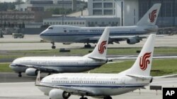资料照- 三架中国国航(Air China)班机停在北京机场的跑到上等待进港或起飞。