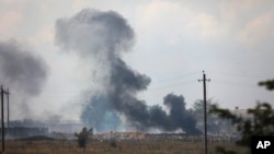 资料照片:俄罗斯占领的克里米亚地区迈斯科耶村附近的一座俄军弹药库爆炸后升起浓烟。(2022年8月16日)