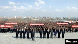 朝鲜人民2013年4月10日在平壤万寿山的已故领导人金日成和金正日的雕像前参与宣誓。 