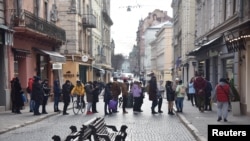 资料照:在俄罗斯总统普京授权对乌克兰东部开展军事行动后,人们在乌克兰利沃夫的一个取款机前排队。