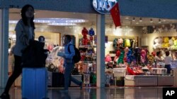 中国上海虹桥火车站里路人经过一家迪士尼专卖店。(2019年10月14日)