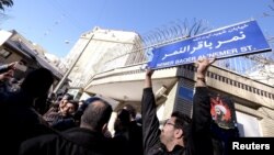 一名伊朗抗议者举着路牌,在沙特阿拉伯驻德黑兰大使馆外抗议(2016年1月3日)